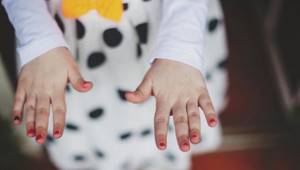 Детские руки с красными ногтями