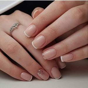 French nude manicure with decorative elements on square nails.