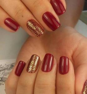 Red manicure with gold print in oriental style