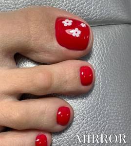 Red shellac pedicure with white flowers