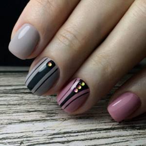 Manicure in light colors with a geometric pattern and rhinestones.