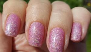 Gently pink manicure with gel polish with glitter, rubbing, rhinestones, silver, black, white, blue, gold. Photo 