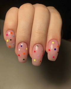 Nude manicure extensions with multi-colored dots