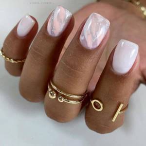 A very gentle manicure in white and pale pink polish for short nails.