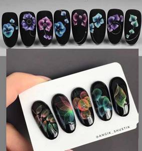Drawing on a black background of nails using the airflowers technique with gel polish