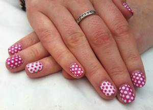 Pink nail design with bright polka dots