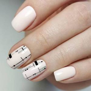 Stylish white manicure with a black graphic pattern.