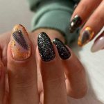Stylish black manicure with sparkles in the photo