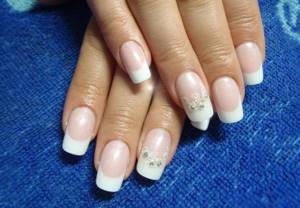 Wedding manicure with rhinestones and a pattern on one finger