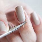 Removing cuticle with scissors.