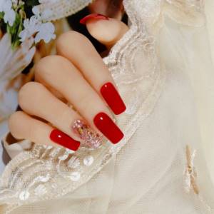 Bright red glossy manicure on square shaped nails.
